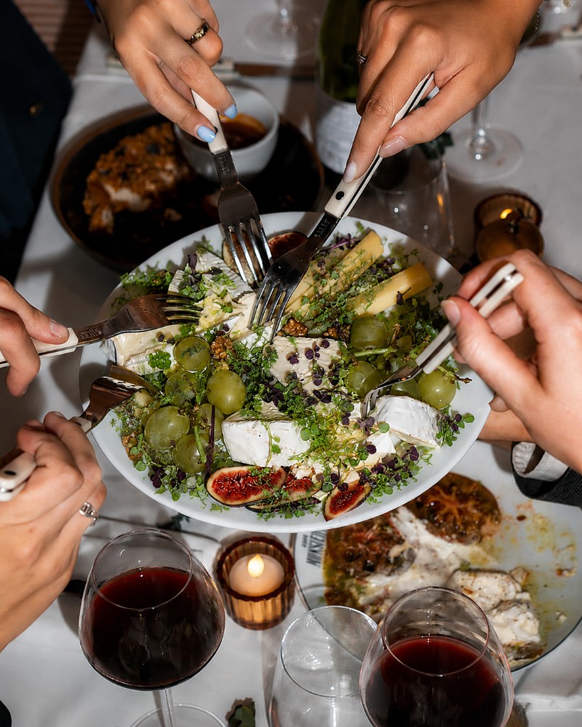 Shared plate of cheese, figs, and microgreens